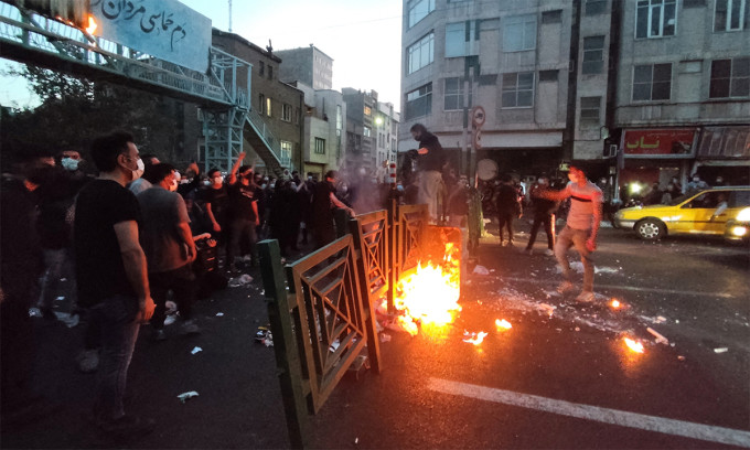 Người biểu tình đốt hàng rào trên đường phố thủ đô Tehran, Iran ngày 21/9. Ảnh: Reuters.