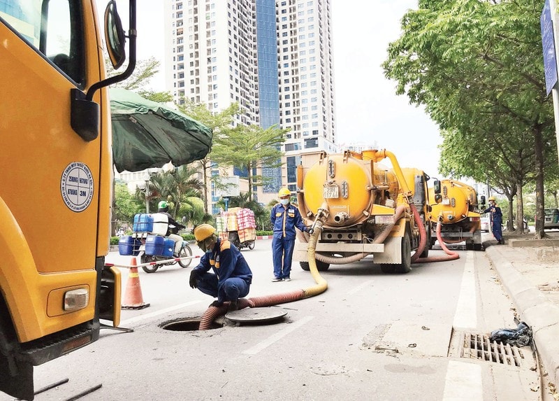 Công nhân Công ty Thoát nước Hà Nội nạo vét hệ thống thoát nước đô thị bằng thiết bị cơ giới.