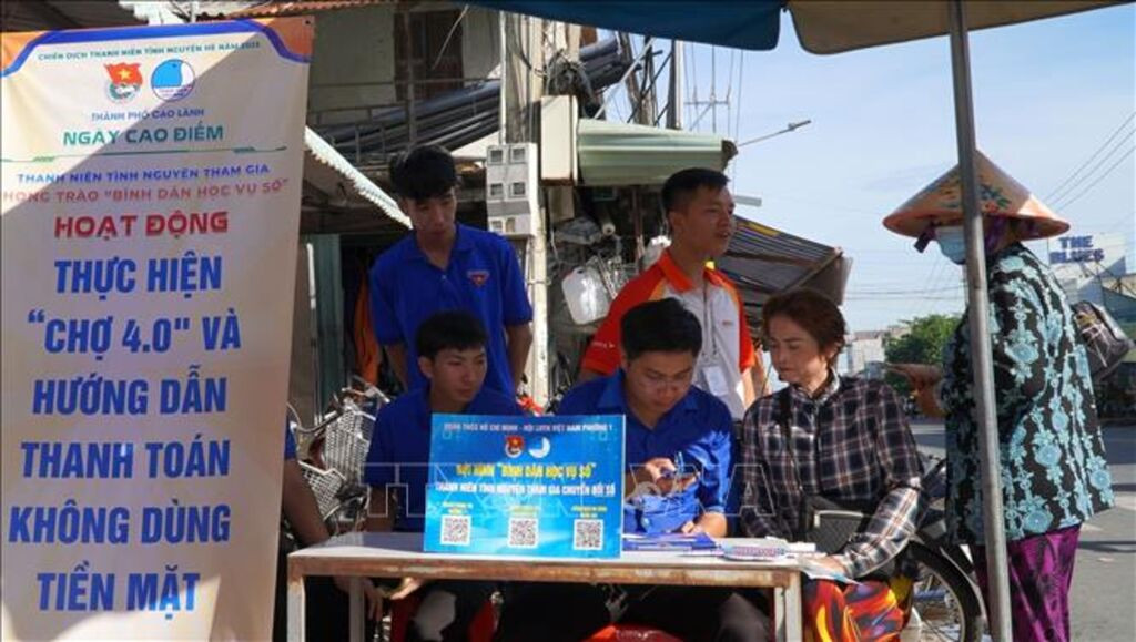 Đội Bình dân học vụ số phường Cao Lãnh (tỉnh Đồng Tháp) hướng dẫn tiểu thương thanh toán không dùng tiền mặt tại chợ Mỹ Ngãi.